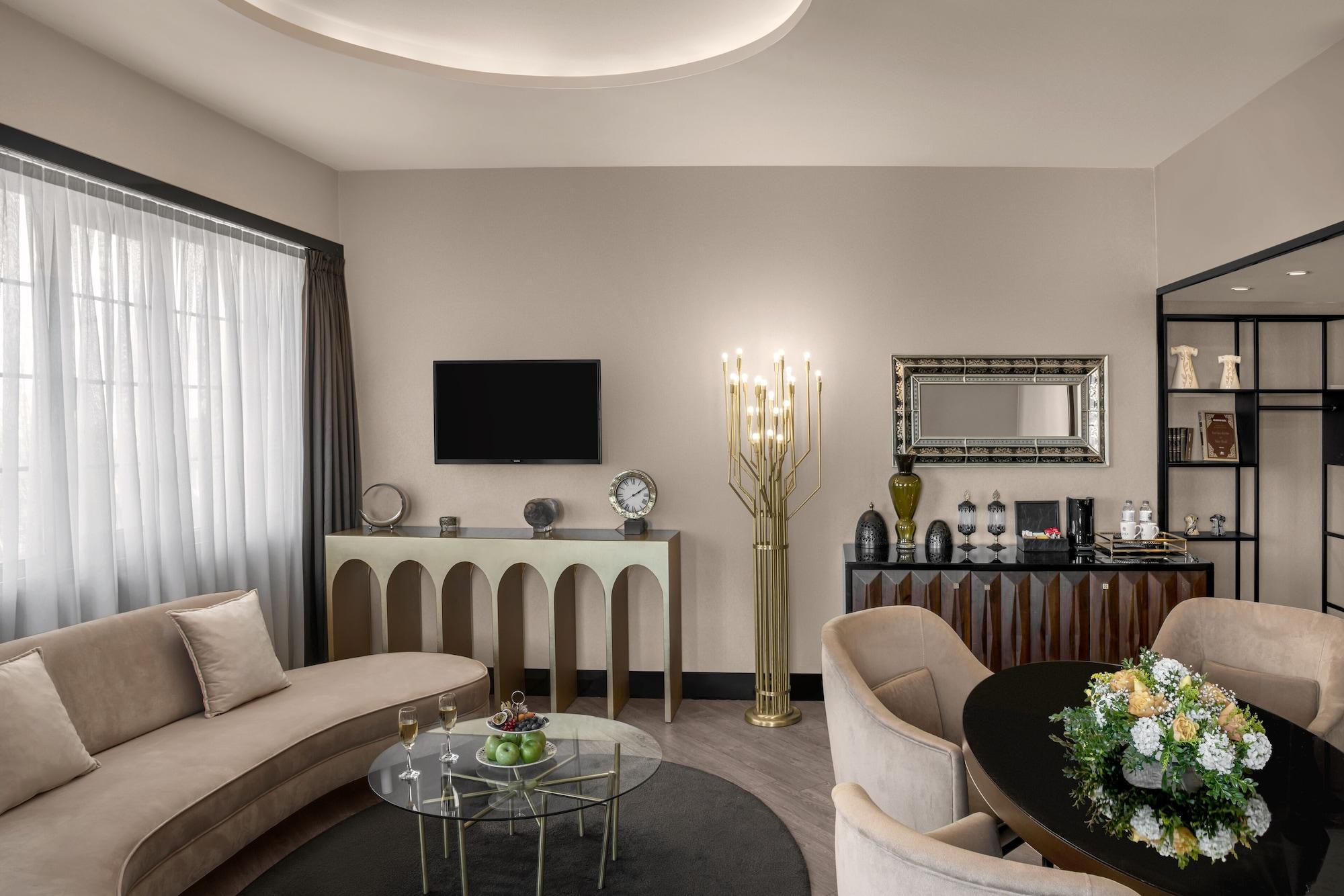 Sura Hagia Sophia Hotel Истанбул Екстериор снимка The photo displays a stylish living room with modern decor. 

- **Seating Area:** There is a curved beige sofa and a round glass coffee table in the center.
- **Wall and Furnishings:** The walls are painted in a light color, with large windows dresse