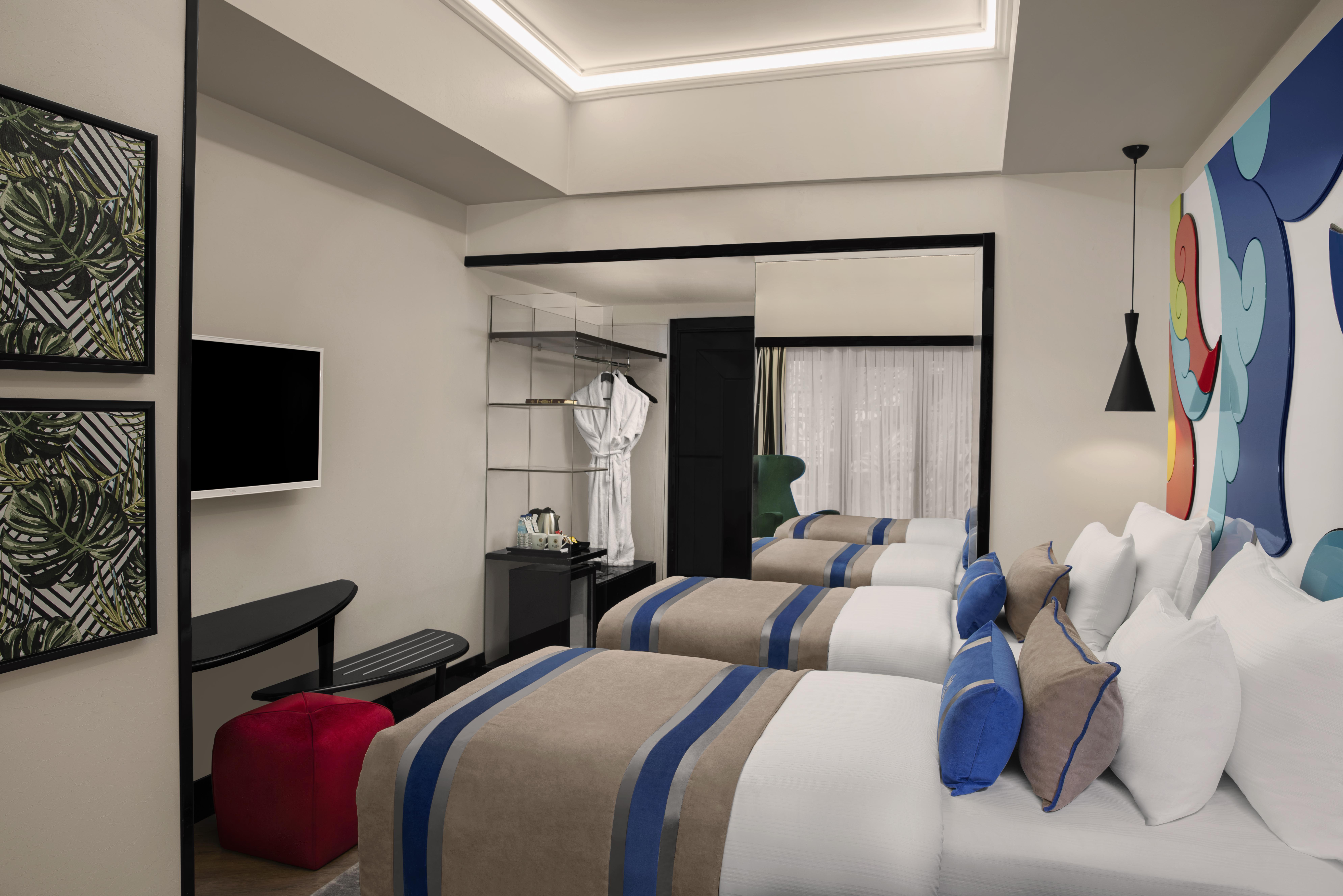 Sura Hagia Sophia Hotel Истанбул Екстериор снимка The photo shows a modern hotel room featuring two beds with light-colored linens and decorative pillows. There's a flat-screen TV mounted on the wall, and a stylish shelf unit beside it. A hanging robe is visible, adding to the room's amenities. The 