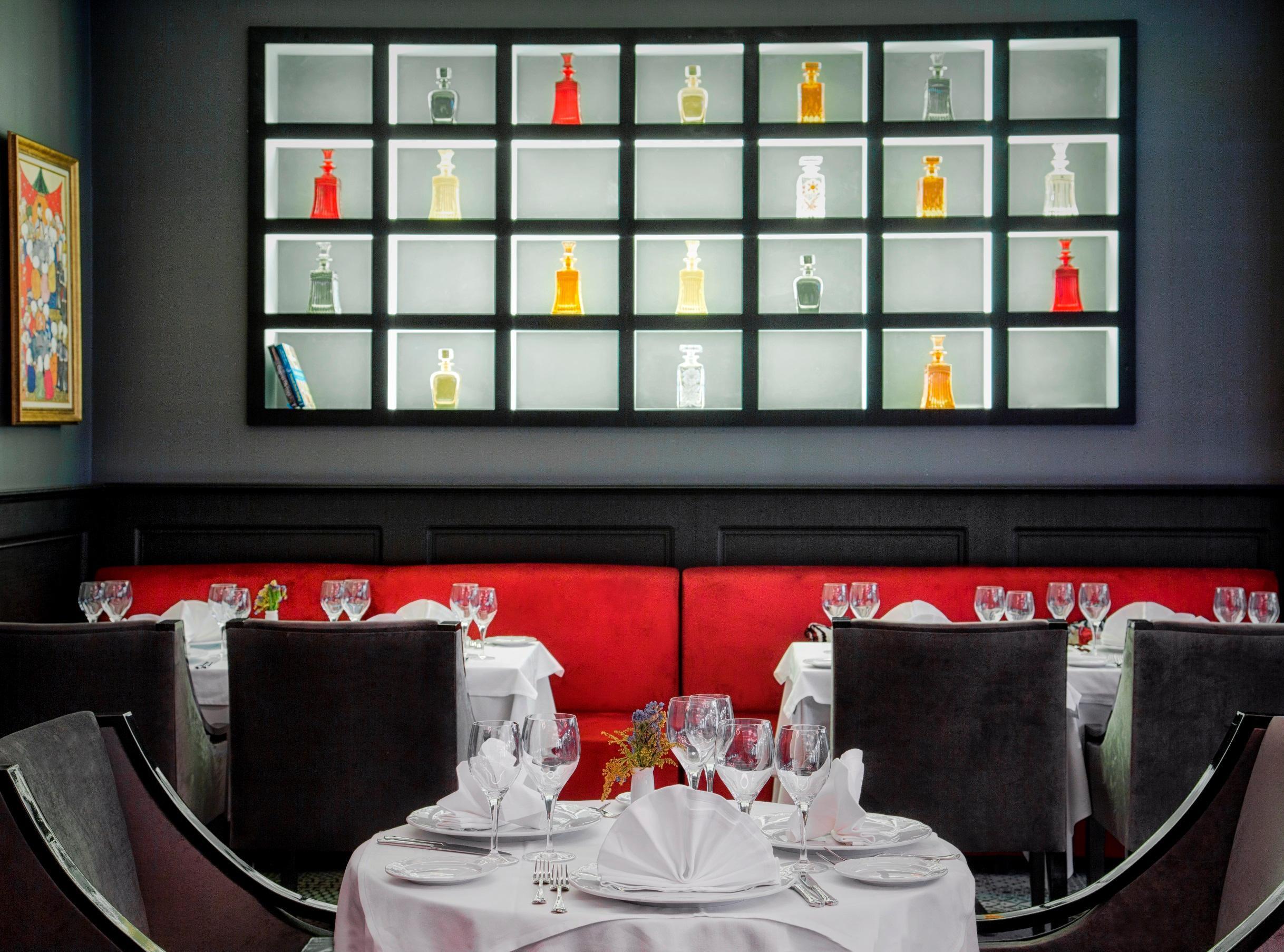 Sura Hagia Sophia Hotel Истанбул Екстериор снимка The photo shows a stylish restaurant interior. In the background, there is a display shelf illuminated with lights, featuring an assortment of colorful bottles. The bottles vary in shape and color, creating an eye-catching visual effect. In the foreg