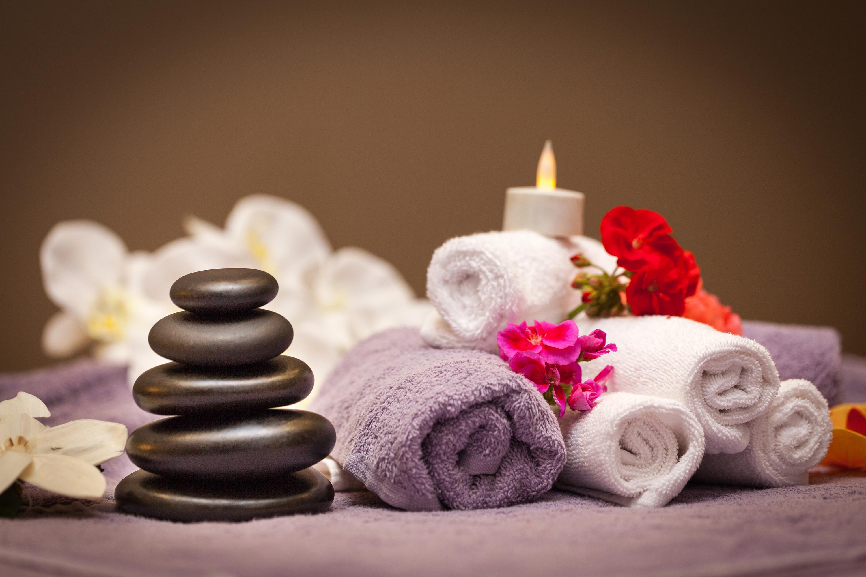 Sura Hagia Sophia Hotel Истанбул Екстериор снимка The photo shows a serene and relaxing spa or wellness setting. In the foreground, there is a stack of smooth black stones, which are often used in spa treatments for massage and relaxation. Nearby are several rolled towels, some white and one purple,