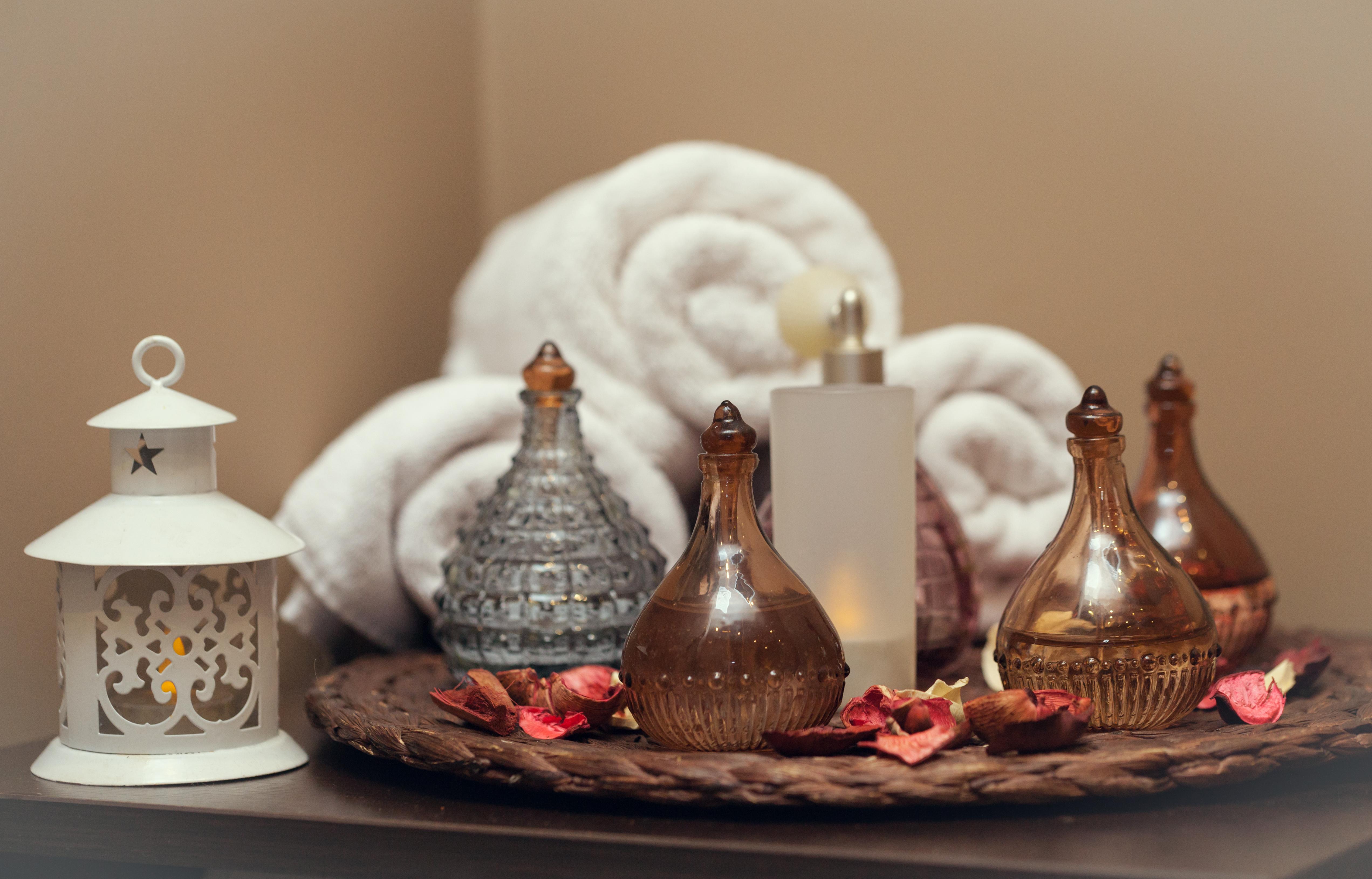 Sura Hagia Sophia Hotel Истанбул Екстериор снимка The photo displays a serene spa or relaxation setting. It features neatly rolled white towels, giving a clean and inviting look. In the foreground, there is a round tray adorned with several decorative glass bottles, which appear to contain oils or s