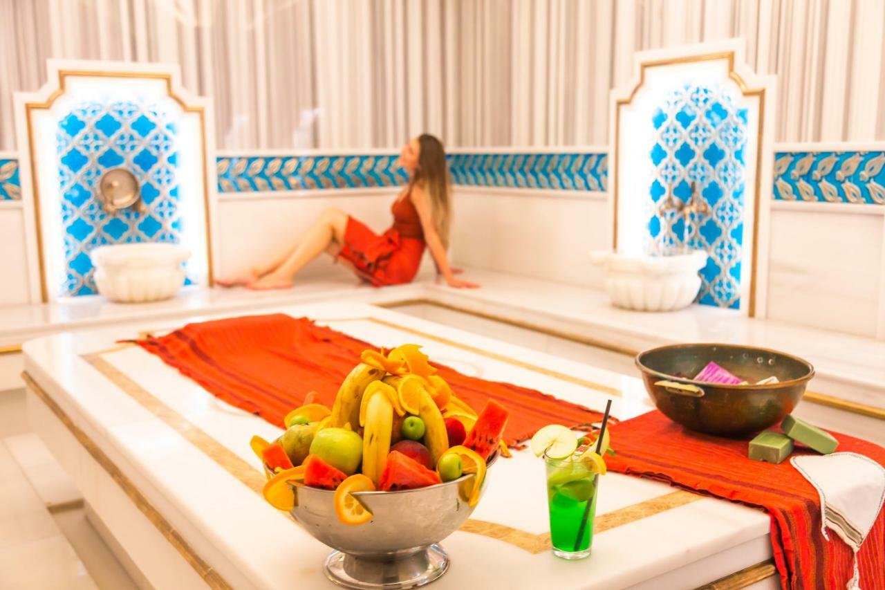 Sura Hagia Sophia Hotel Истанбул Екстериор снимка The photo depicts a luxurious and relaxing spa setting. In the foreground, there is a bowl filled with an assortment of colorful fruits, including bananas, watermelon, and apples. There is also a green drink in a glass with a straw, suggesting a refr